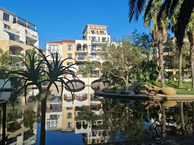 a reflection of a building in the water with palm trees at Island Club by Smart City Stays in Cape Town