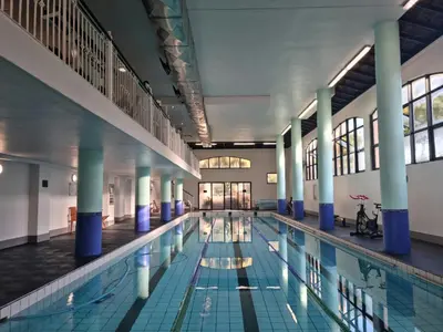 a large swimming pool with blue columns in a building at Island Club by Smart City Stays in Cape Town