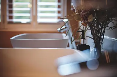 a bathroom sink with a vase with flowers in it at The Cottage Farm in Stellenbosch