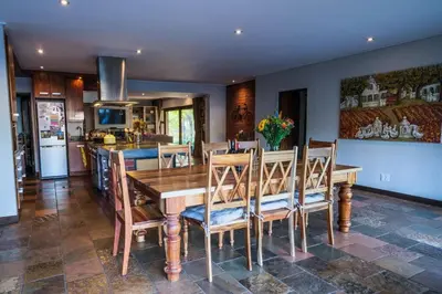 a kitchen and dining room with a wooden table and chairs at Home in Cape Town-The Homestead in Stellenbosch