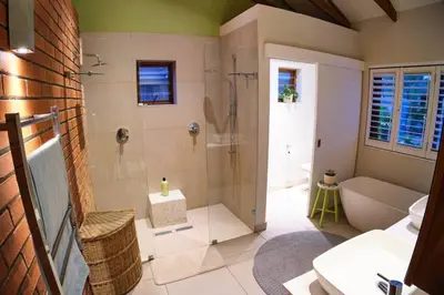 a bathroom with a shower and a toilet and a sink at Home in Cape Town-The Homestead in Stellenbosch