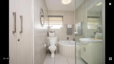 a bathroom with a toilet and a tub and a sink at Strand Getaways Apartment in Cape Town