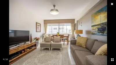 a living room with a couch and a flat screen tv at Strand Getaways Apartment in Cape Town