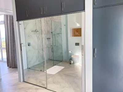a bathroom with a shower with a glass door at Beach & Mountain Retreat within a UNESCO Biosphere in Rooiels