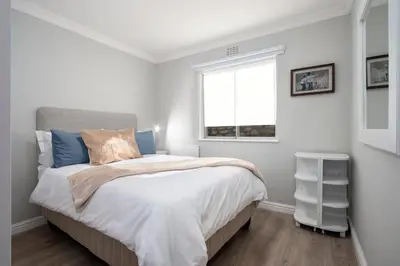 a bedroom with a bed and a window at 29@Whale Rock Estate in Hermanus