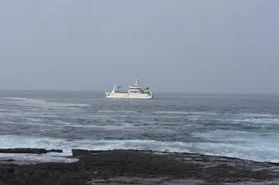 a boat floating in the ocean near the shore at 29@Whale Rock Estate in Hermanus