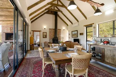 a kitchen and living room with a wooden table and chairs at Fynbosrust in Wolseley