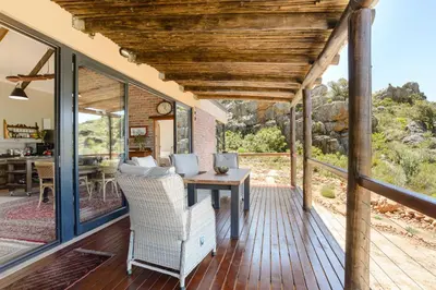 a screened porch with a table and chairs on it at Fynbosrust in Wolseley