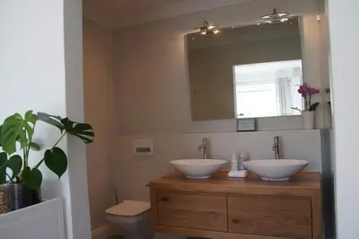 a bathroom with two sinks and a toilet and a mirror at House on Charme in Stellenbosch