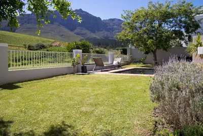 a yard with a fence and a chair and a pool at House on Charme in Stellenbosch