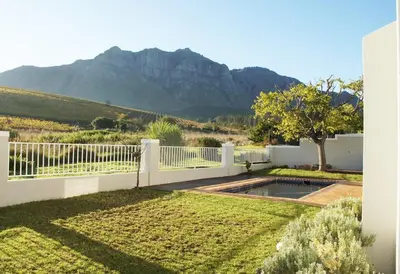 a backyard with a white fence and a swimming pool at House on Charme in Stellenbosch