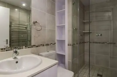 a bathroom with a sink and a glass shower at Ocean View C403 by CTHA in Bloubergstrand
