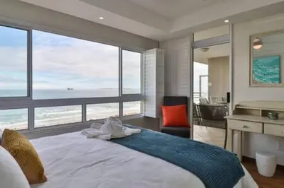 a bedroom with a bed with a view of the ocean at Ocean View C403 by CTHA in Bloubergstrand
