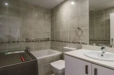 a bathroom with a sink and a toilet and a tub at Ocean View C403 by CTHA in Bloubergstrand
