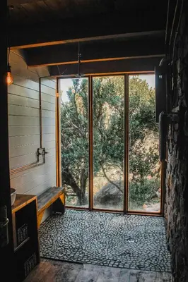 an empty room with a large window and a bench at Stonewood Mountain Cabin in Breerivier