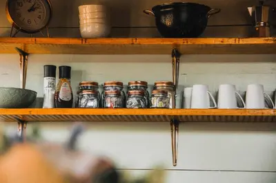 a wooden shelf with spices and a clock on it at Stonewood Mountain Cabin in Breerivier