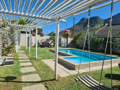 a pool in a backyard with a swing and a house at 57 on Vermont in Hermanus