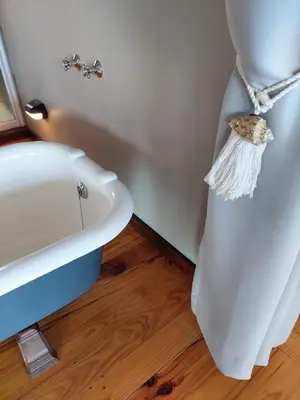 a bathroom with a white tub and a sink at Brandys beach house bettys bay in Bettyʼs Bay