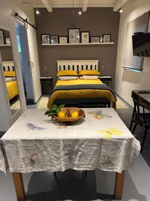 a bedroom with a bed and a table with a bowl of fruit on it at Open Room Comfort in Cape Town