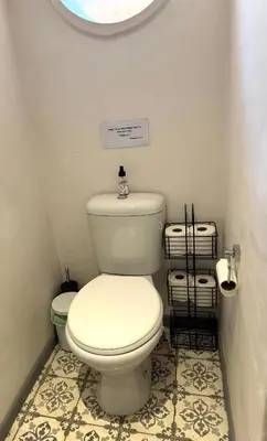 a bathroom with a toilet with a sign above it at Open Room Comfort in Cape Town