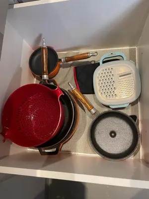 a drawer filled with cooking utensils on a shelf at Open Room Comfort in Cape Town