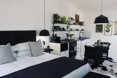a bedroom with a bed and a kitchen with a table at Brenaissance Wine & Stud Estate in Stellenbosch