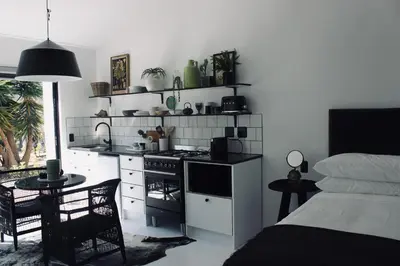 a kitchen with a stove and a table and a bed at Brenaissance Wine & Stud Estate in Stellenbosch