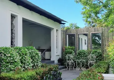 a house with a patio with chairs and a fence at Brenaissance Wine & Stud Estate in Stellenbosch