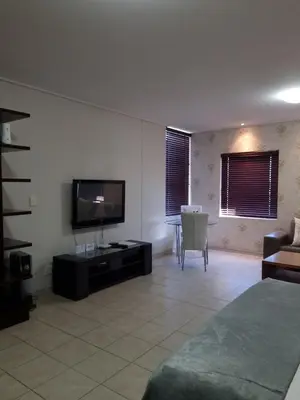 a living room with a flat screen tv and a couch at Manhattan by Smart City Stays in Cape Town