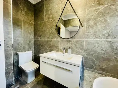 a bathroom with a toilet and a sink and a mirror at Cozier Glitz in Cape Town