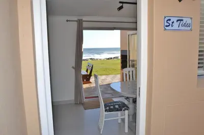 a dining room with a table and a view of the ocean at Hermanus Beach Club - St Tides House 19 in Hermanus