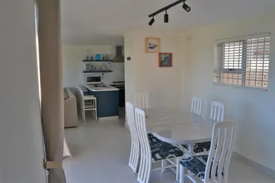 a dining room and kitchen with a table and chairs at Hermanus Beach Club - St Tides House 19 in Hermanus