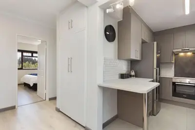 a kitchen with white cabinets and a counter top at Cisterama 102 in Cape Town