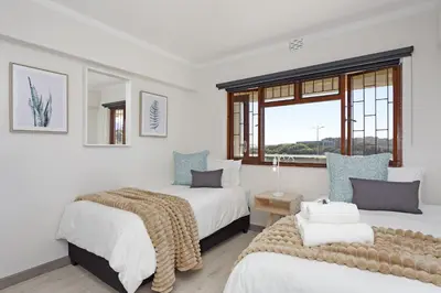 two beds in a room with a window at Cisterama 102 in Cape Town