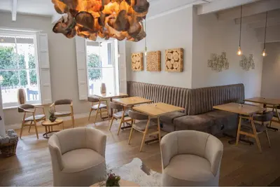 a restaurant with tables and chairs and a chandelier at Macaron Boutique Guest House in Franschhoek