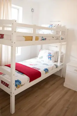 a white bunk bed in a room with a bed sqor at Luxury @ the Ocean in Hermanus