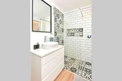 a white bathroom with a sink and a mirror at Luxury @ the Ocean in Hermanus