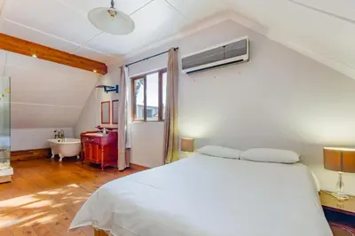 a bedroom with a bed and a tub and a sink at the MANOR house by Kana Guest Farm - Ideal for groups in Stellenbosch