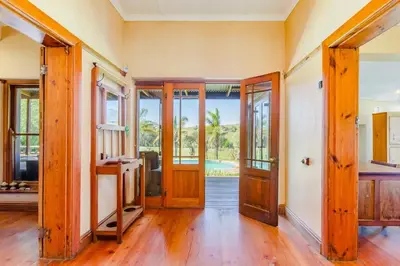 an open living room with wooden doors and wooden floors at the MANOR house by Kana Guest Farm - Ideal for groups in Stellenbosch