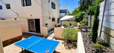 a blue ping pong table in the courtyard of a building at Walters Lane Deluxe Garden Apartment 3 - No loadshedding in Cape Town