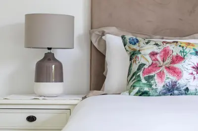 a bed with a pillow and a lamp on a night stand at Birdsong in Hermanus