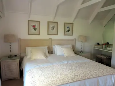 a bedroom with a large white bed with two lamps at Featherbed in Somerset West