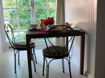 a table with two chairs in front of a window at Featherbed in Somerset West