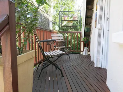 a wooden deck with a bench on a porch at Featherbed in Somerset West