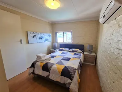 a bedroom with a bed with a checkered blanket at Walters Lane Comfort Apartment 2 - No Loadshedding in Cape Town
