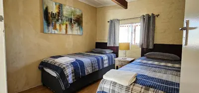 a bedroom with two beds and a picture on the wall at Walters Lane Comfort Apartment 2 - No Loadshedding in Cape Town
