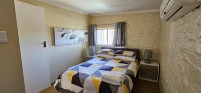 a small bedroom with a bed and a window at Walters Lane Comfort Apartment 2 - No Loadshedding in Cape Town