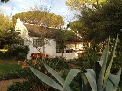 a white house with a garden in front of it at Mooi Bly in Paarl