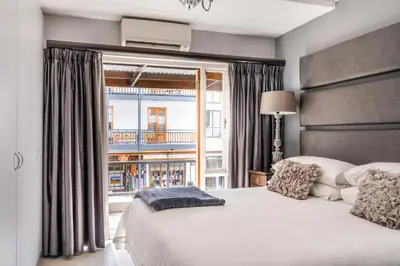 a bedroom with a large bed and a window at Avemore Jan Cats No 5 full backup power in Stellenbosch