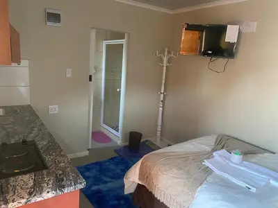 a bedroom with a bed and a shower in a room at SABATH LODGE in Cape Town
